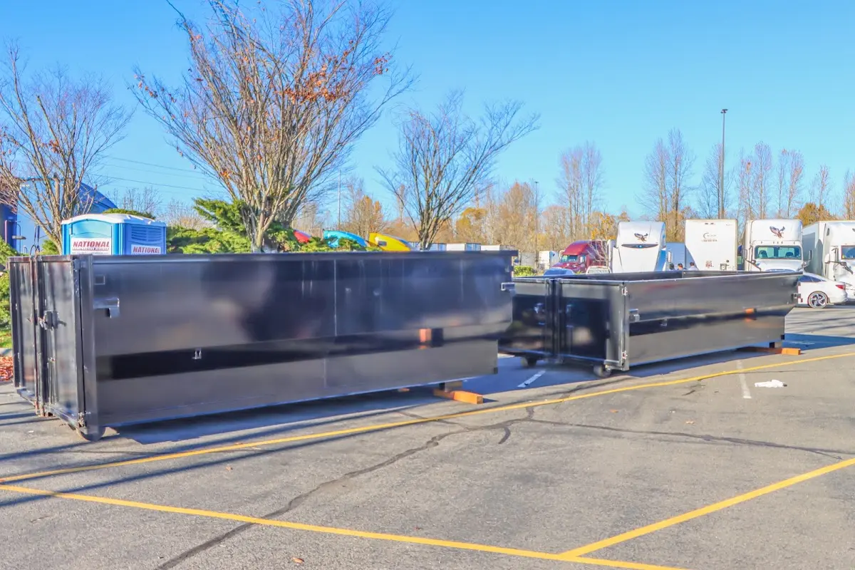 Professional dumpster rental service with roll-off container on residential driveway in Pennfield